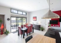 Espace cuisine salle à manger de la maison individuelle avec ouverture sur la terrasse et le jardin.