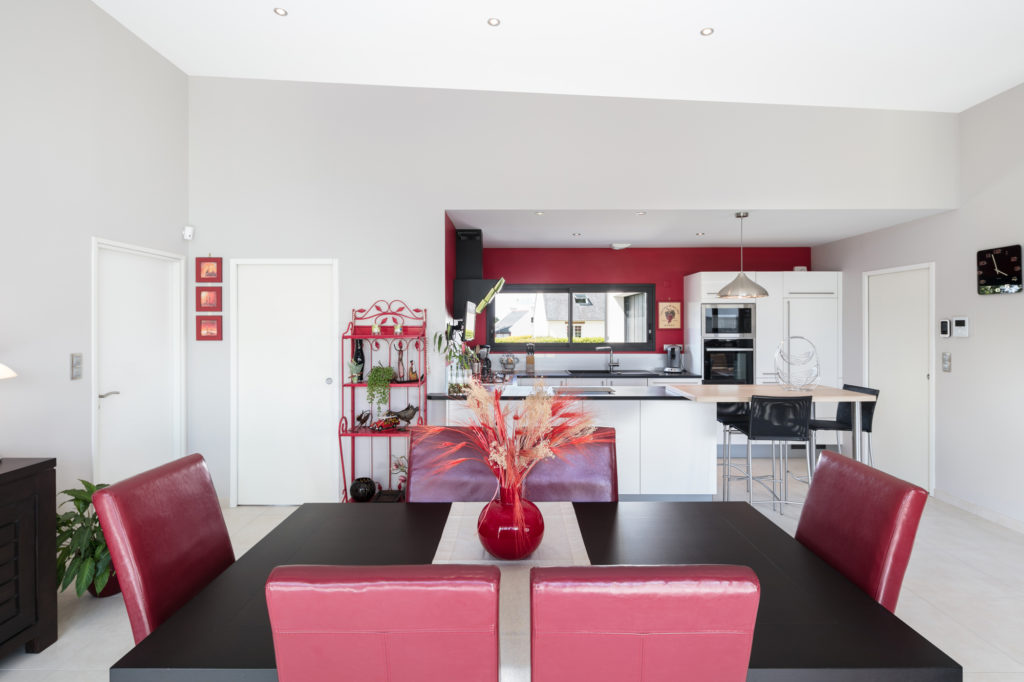 Cuisine ouverte sur la salle à manger avec mobilier de qualité et mur de couleur