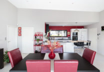 Cuisine ouverte sur la salle à manger avec mobilier de qualité et mur de couleur