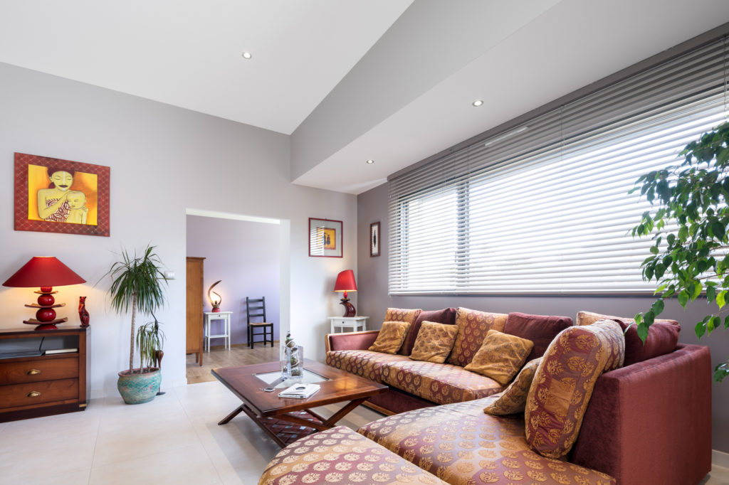 Pièce à vivre lumineuse grâce aux grandes ouvertures et utilisation d'un mobilier de qualité pour apporter du caractère à l'ensemble