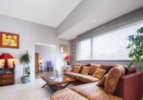 Pièce à vivre lumineuse grâce aux grandes ouvertures et utilisation d'un mobilier de qualité pour apporter du caractère à l'ensemble