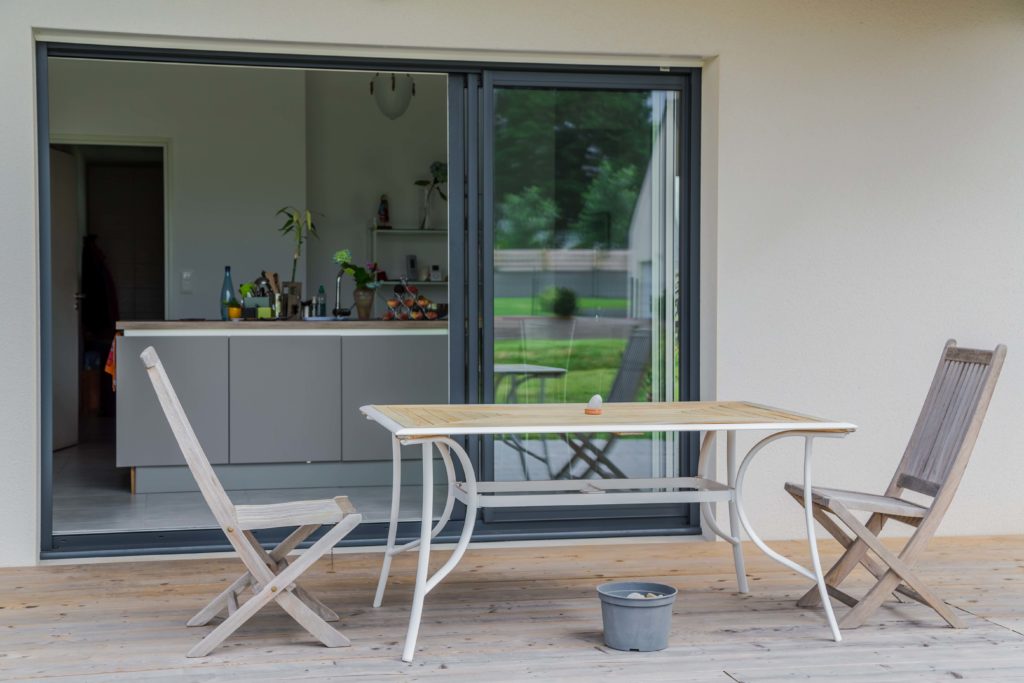 Les larges baies vitrées de cette maison de plain pied apportent luminosité à l'ensemble et ouvre résolument les pièces de vie sur l'extérieur