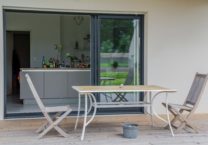 Les larges baies vitrées de cette maison de plain pied apportent luminosité à l'ensemble et ouvre résolument les pièces de vie sur l'extérieur